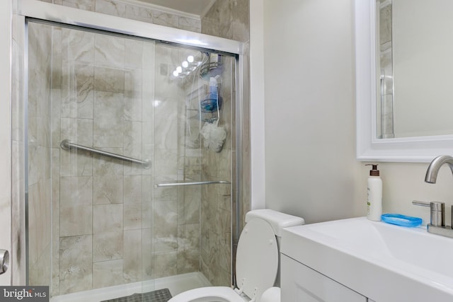 bathroom featuring toilet, a shower stall, and vanity
