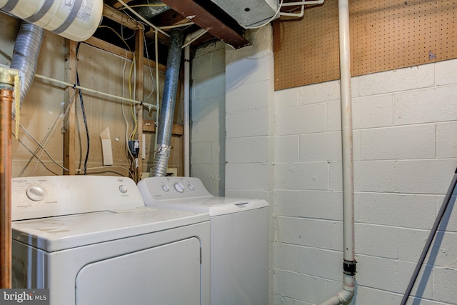 clothes washing area featuring separate washer and dryer and laundry area