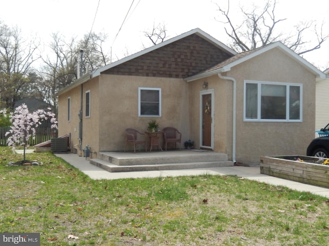 view of front of home featuring stucco siding and a front yard