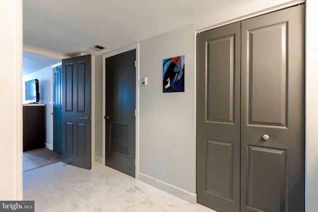 hallway featuring baseboards and visible vents