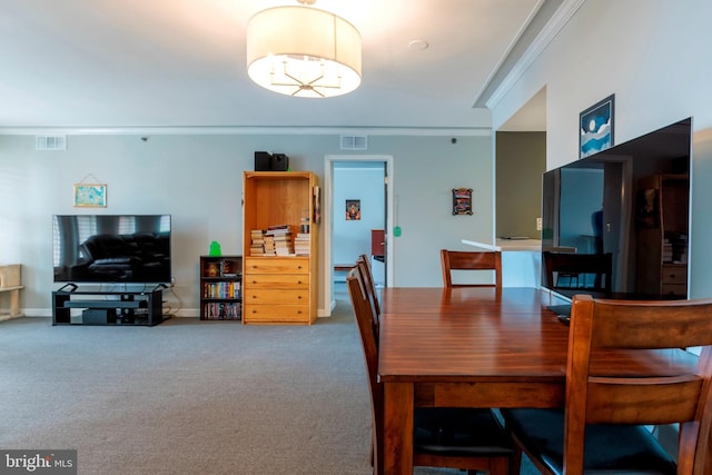 carpeted dining room featuring ornamental molding and visible vents
