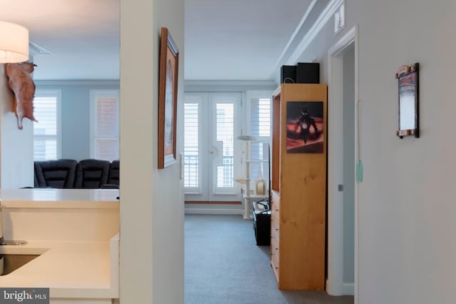 hallway featuring crown molding, plenty of natural light, and carpet floors