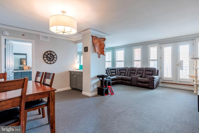 living room with crown molding, baseboards, dark colored carpet, and visible vents