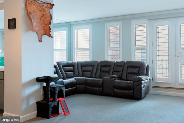 carpeted living room featuring baseboards and crown molding