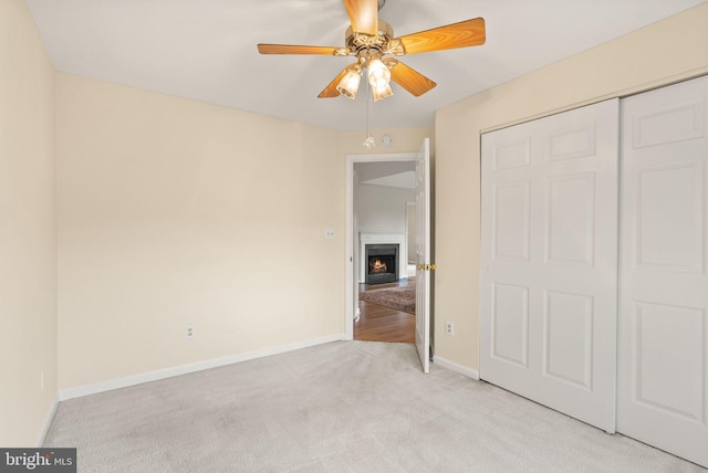 8075 Lacy Dr Unit 303, Manassas, VA 20109 - unfurnished bedroom featuring a ceiling fan, a closet, a fireplace with flush hearth, baseboards, and light carpet