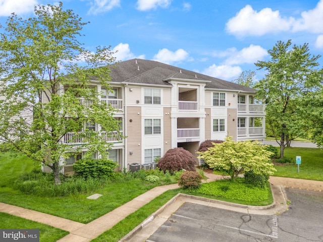 8075 Lacy Dr Unit 303, Manassas, VA 20109 - view of building exterior featuring central air condition unit and uncovered parking