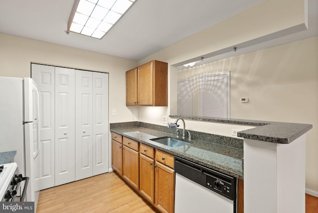 8075 Lacy Dr Unit 303, Manassas, VA 20109 - kitchen with a sink, white appliances, dark stone countertops, brown cabinets, and light wood finished floors