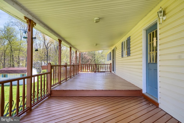 wooden terrace featuring a porch and an outdoor structure