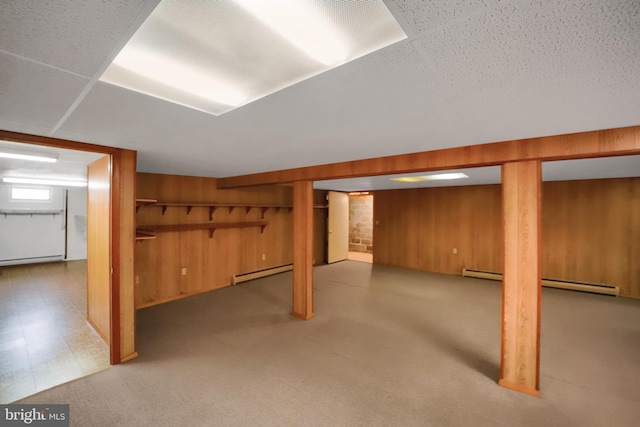 below grade area featuring wooden walls and baseboard heating