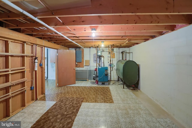 unfinished below grade area featuring a heating unit, tile patterned floors, heating fuel, and electric panel