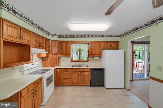 kitchen featuring white appliances, light countertops, under cabinet range hood, brown cabinets, and a sink