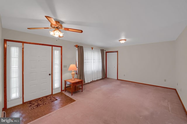 entryway featuring baseboards and a ceiling fan