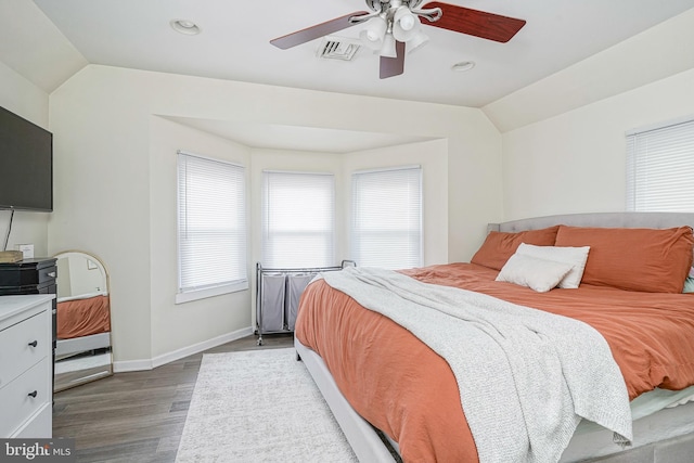 bedroom featuring visible vents, wood finished floors, lofted ceiling, baseboards, and a ceiling fan