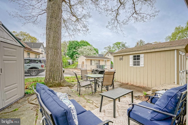 view of patio featuring fence, outdoor dining area, an outdoor hangout area, and an outbuilding