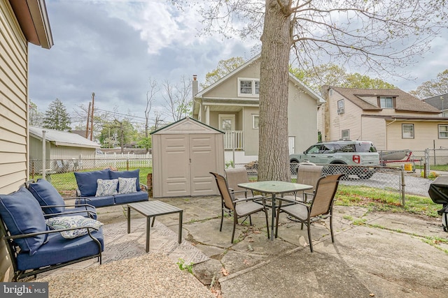 view of patio / terrace featuring fence, outdoor dining area, an outdoor living space, a storage shed, and an outbuilding