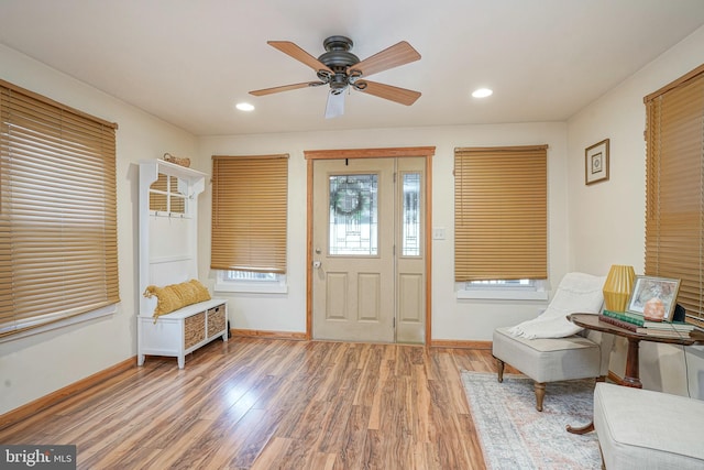 foyer with baseboards, ceiling fan, and light wood-style flooring