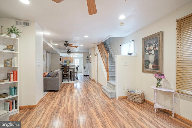 interior space with stairway, baseboards, light wood-type flooring, and visible vents
