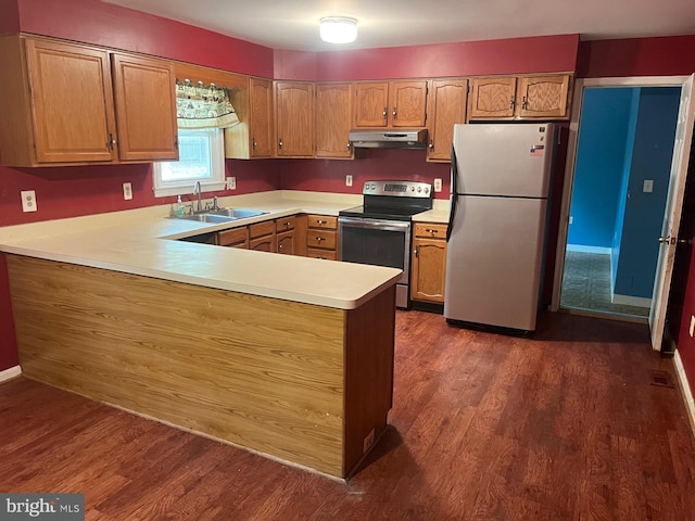 kitchen featuring appliances with stainless steel finishes, a sink, light countertops, a peninsula, and under cabinet range hood