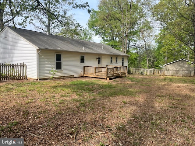 back of house with a yard, a wooden deck, and a fenced backyard