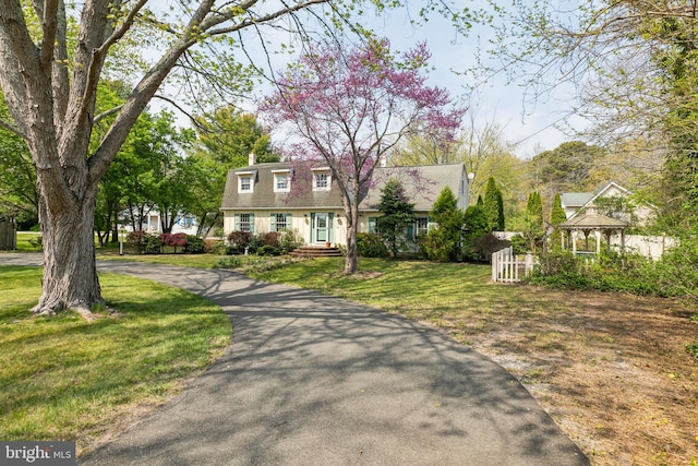 view of front of house featuring aphalt driveway, a gazebo, and a front yard
