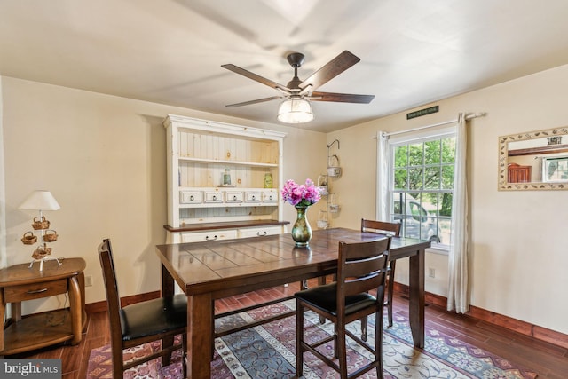 dining space with a ceiling fan, wood finished floors, and baseboards
