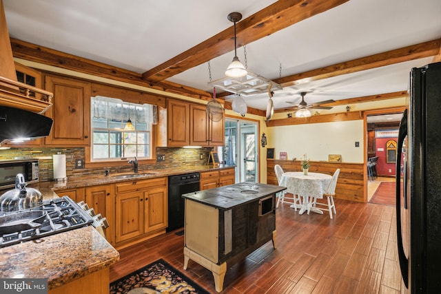 kitchen featuring dark wood-style floors, a sink, decorative backsplash, black appliances, and a ceiling fan