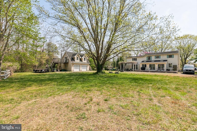 view of yard featuring a deck, stairs, and a garage