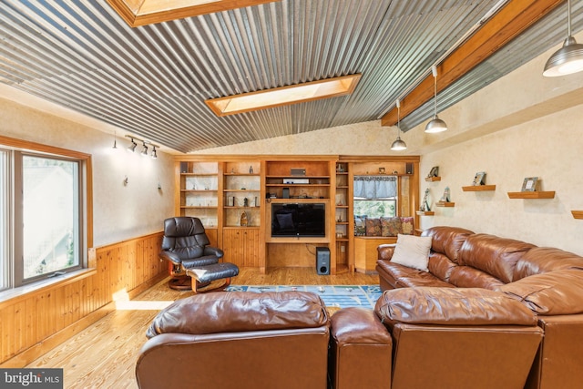 living room featuring wooden ceiling, wood finished floors, a wainscoted wall, wooden walls, and lofted ceiling with skylight
