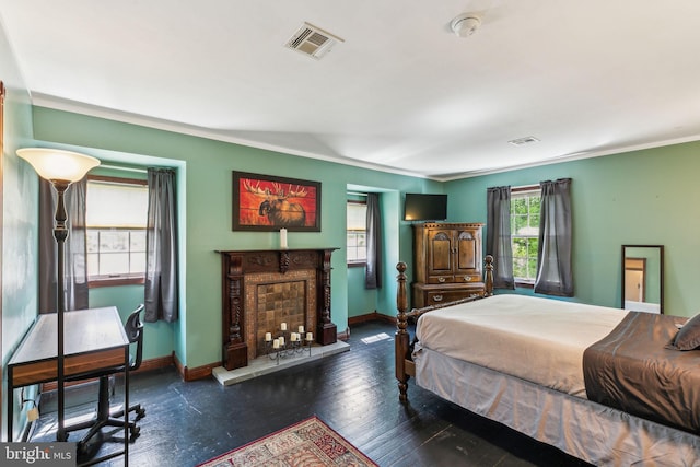 bedroom with baseboards, visible vents, and a fireplace with raised hearth