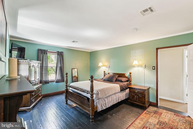 bedroom featuring dark wood-type flooring, visible vents, crown molding, and baseboards