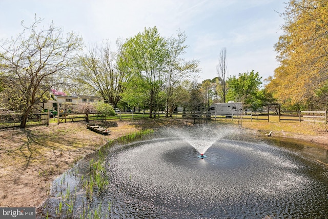 view of community with fence and a water view