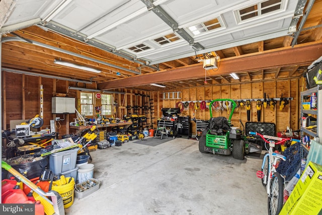 garage with a garage door opener and a workshop area