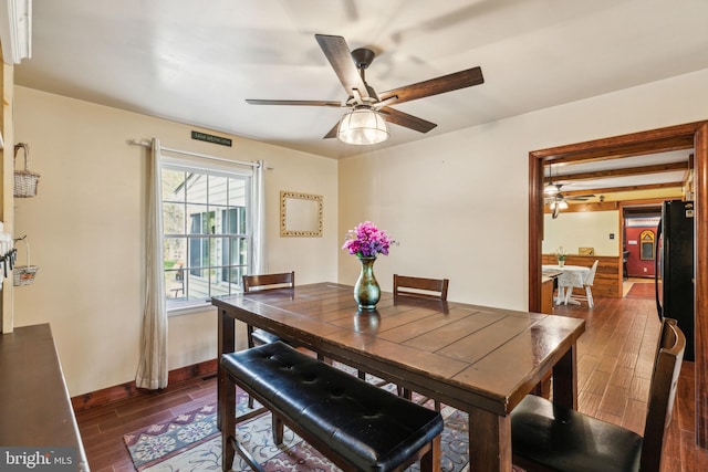 dining room with ceiling fan, baseboards, and dark wood-type flooring