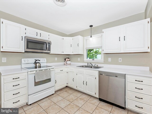 kitchen with a sink, white cabinetry, appliances with stainless steel finishes, and light tile patterned flooring