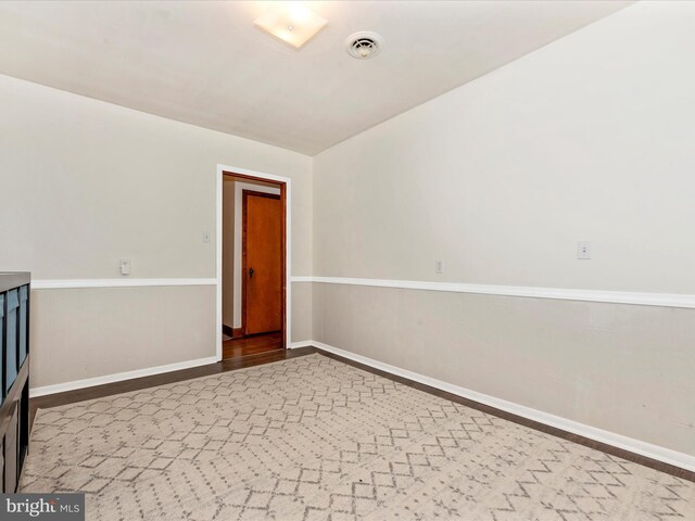 unfurnished room featuring visible vents, baseboards, and wood finished floors