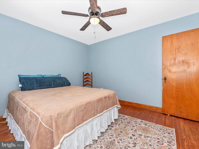 bedroom featuring baseboards, a ceiling fan, and wood finished floors