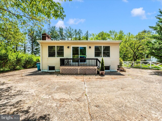 rear view of property with fence and a chimney