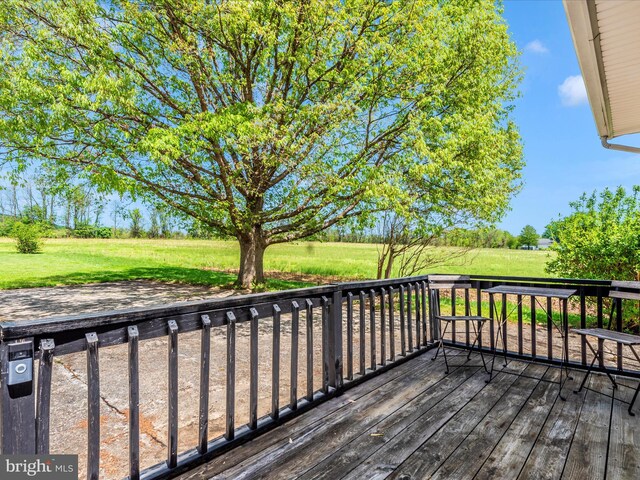 wooden terrace featuring a lawn