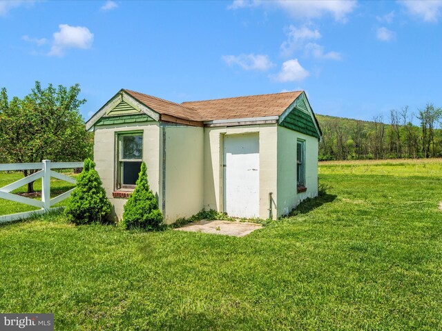 view of outbuilding with fence and an outdoor structure
