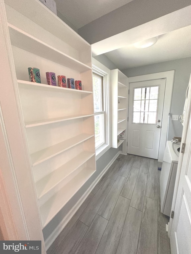 mudroom featuring baseboards, wood finished floors, and washer and dryer