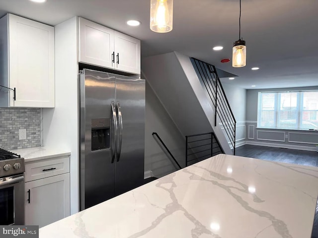 kitchen with appliances with stainless steel finishes, light stone countertops, dark wood finished floors, and white cabinetry