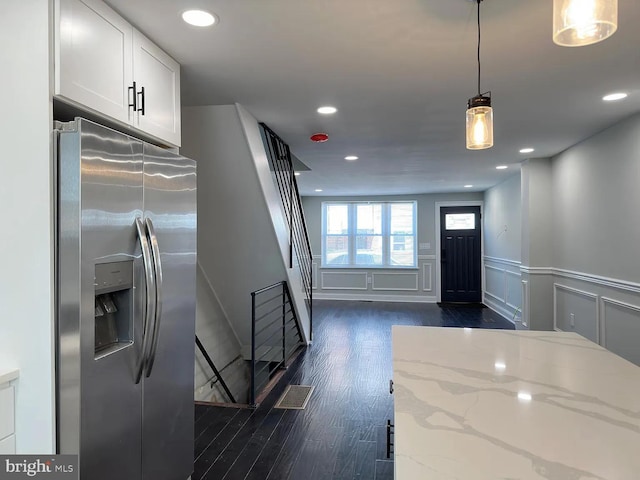 entrance foyer with a decorative wall, a wainscoted wall, visible vents, dark wood-style floors, and stairway