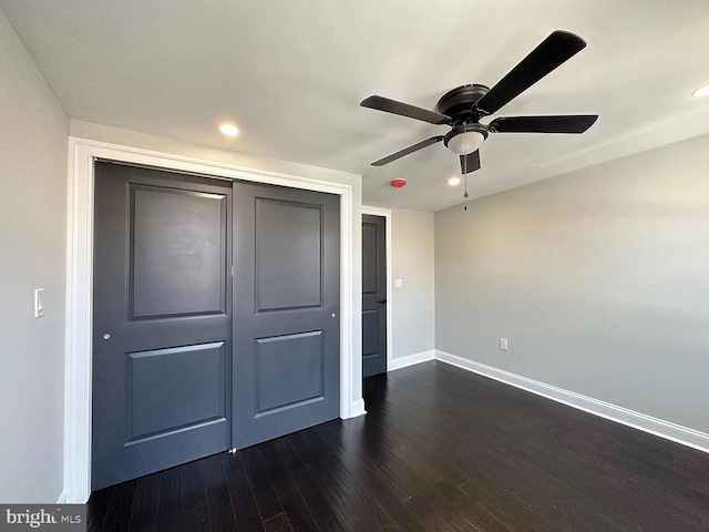 unfurnished bedroom featuring dark wood-style flooring, recessed lighting, baseboards, a ceiling fan, and a closet