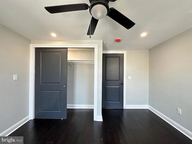 unfurnished bedroom with baseboards, dark wood finished floors, and a closet