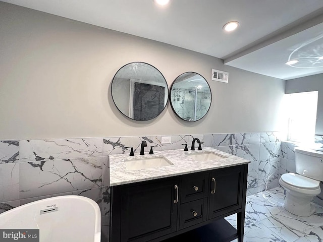 bathroom with visible vents, a sink, marble finish floor, and tile walls