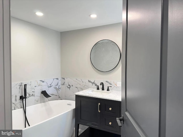 bathroom with vanity, recessed lighting, and a freestanding bath