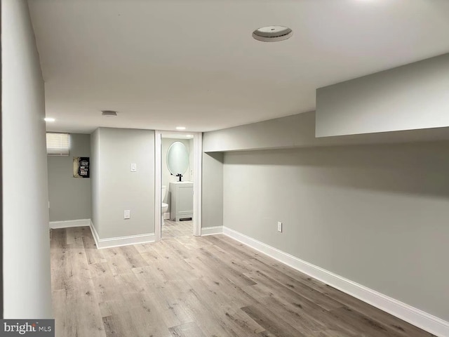 finished below grade area with baseboards and light wood-style flooring