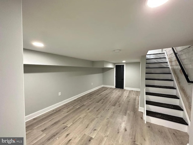 finished basement featuring baseboards, recessed lighting, wood finished floors, and stairway