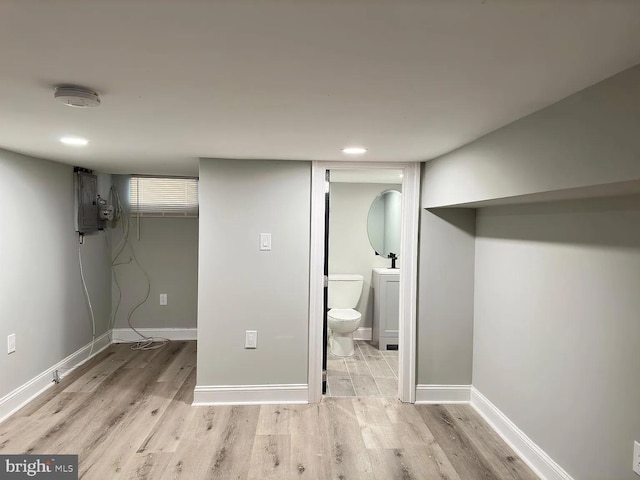 finished below grade area featuring recessed lighting, baseboards, and wood finished floors