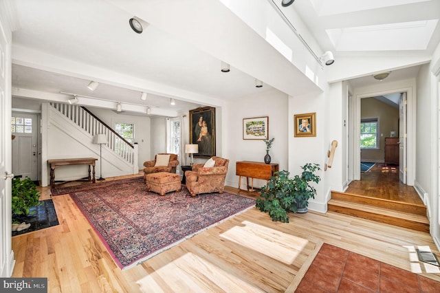 living room featuring stairs, wood finished floors, and baseboards